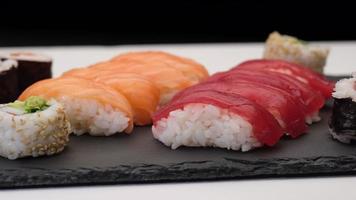 surtido de sushi con nigiri de salmón, nigiri de atún, hosomaki y uramaki. maki de pescado crudo y arroz comida asiática japonesa. video