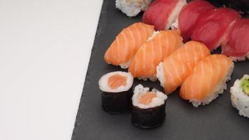 variedade de sushi com nigiri de salmão, nigiri de atum, hosomaki e uramaki. peixe cru maki e arroz comida asiática japonesa. video