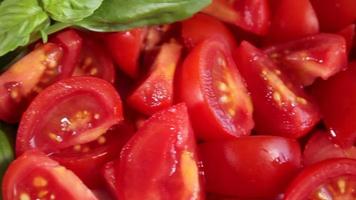 tomates crudos en rodajas y albahaca. alimentos orgánicos veganos vegetarianos saludables de cerca. tiro deslizante video