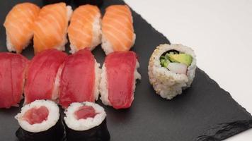 assortiment de sushis avec nigiri au saumon, nigiri au thon, hosomaki et uramaki. maki de poisson cru et riz cuisine asiatique japonaise. video