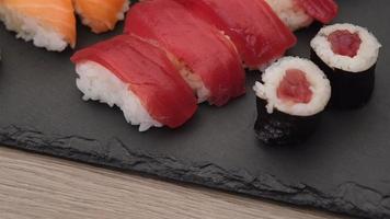 variedade de sushi com nigiri de salmão, nigiri de atum, hosomaki e uramaki. peixe cru maki e arroz comida asiática japonesa. video