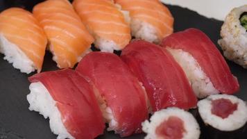 variedade de sushi com nigiri de salmão, nigiri de atum, hosomaki e uramaki. peixe cru maki e arroz comida asiática japonesa. video