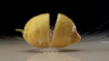 Fresh sliced lemon falling and splashing on water at slow motion