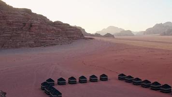 Wadi Rum desert on sunrise, Jordan. Beautiful view of bedouin camp from above with tents lined up and red rock formations. Panoramic landscape with nobody video