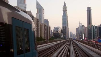dubai, emiratos árabes unidos, 2022 - metro en tren en dubai con museo del futuro y fondo del cielo del atardecer video