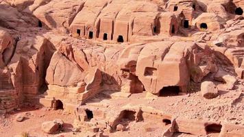 vista panorâmica em câmera lenta casas de cavernas no local de petra com monumento de teatro video