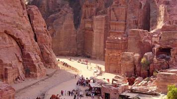 Top view tourist visit sightseeing Royal tombs structures in ancient city of Petra, Jordan. It is know as the Loculi. Petra has led to its designation as UNESCO World Heritage Site video