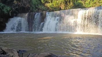 A cachoeira sri dit é uma cachoeira pequena e arborizada de um nível com luz solar em khao kho, província de phetchabun, tailândia. video