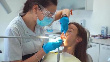 tandarts in unform behandelt meisjes tanden in kliniek video