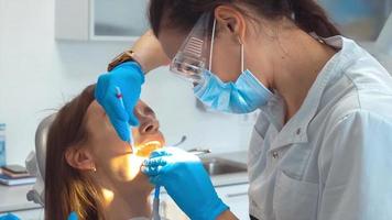 retrato de dentista trata dentes para uma menina em uma clínica video