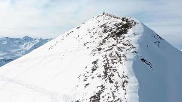 deux gars copains se détendre se reposer sur la neige profiter du panorama de la montagne après une randonnée avant de descendre en freeride dans la région de kobi de la station de ski de gudauri dans la station de ski de géorgie, caucase video
