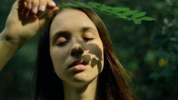 girl closes the rays of the Sun with a Palm in the forest video