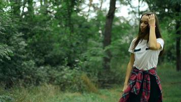 brunette walks during the day in the green forest video