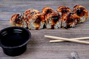 Traditional delicious fresh sushi roll set on a black background with reflection. Sushi roll with rice, cream cheese, avocado, salmon, sesame. Philadelphia. Sushi menu. Japanese kitchen, photo