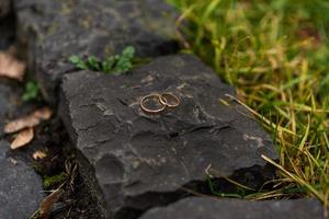 anillos de boda en la mano. dos anillos de boda en el suelo con anillos de boda en contraste en el suelo, en el suelo, en el piano, en la mano sobre hierba o piedras, foto