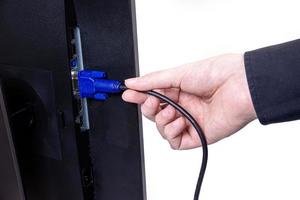 IT engineer Man hand inserts cable into monitor. Man hand connecting the DVI cable for monitor to computer PC. VGA DVI DisplayPort and power cable. close up in the hands of an . isolated photo