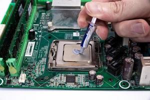 ingeniero reparador tomados de la mano en el procesador de chips de guantes negros, cpu para insertar en el zócalo de la placa base de la computadora. el concepto de hardware tecnológico a la luz de neón foto