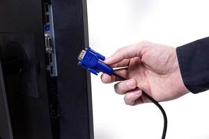 IT engineer Man hand inserts cable into monitor. Man hand connecting the DVI cable for monitor to computer PC. VGA DVI DisplayPort and power cable. close up in the hands of an . isolated photo