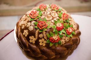 Wedding bread - loaf cake. Wedding bread. A loaf is decorated with flowers, stables, ears of dough. Wedding. Bride and groom. photo