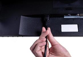 IT engineer Man hand inserts cable into monitor. Man hand connecting the DVI cable for monitor to computer PC. VGA DVI DisplayPort and power cable. close up in the hands of an . isolated photo