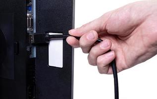 IT engineer Man hand inserts cable into monitor. Man hand connecting the DVI cable for monitor to computer PC. VGA DVI DisplayPort and power cable. close up in the hands of an . isolated photo