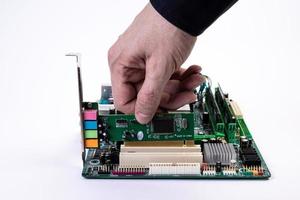 ingeniero reparador tomados de la mano en el procesador de chips de guantes negros, cpu para insertar en el zócalo de la placa base de la computadora. el concepto de hardware tecnológico a la luz de neón foto