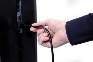 IT engineer Man hand inserts cable into monitor. Man hand connecting the DVI cable for monitor to computer PC. VGA DVI DisplayPort and power cable. close up in the hands of an . isolated photo