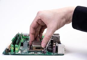 Engineer repairman holding hands in black gloves chip processor, CPU to insert into the socket of the computer motherboard. The concept of technology hardware in the neon light photo