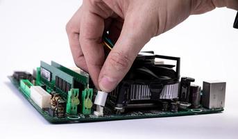 Engineer repairman holding hands in black gloves chip processor, CPU to insert into the socket of the computer motherboard. The concept of technology hardware in the neon light photo