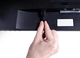 IT engineer Man hand inserts cable into monitor. Man hand connecting the DVI cable for monitor to computer PC. VGA DVI DisplayPort and power cable. close up in the hands of an . isolated photo