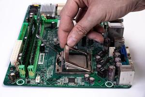 ingeniero reparador tomados de la mano en el procesador de chips de guantes negros, cpu para insertar en el zócalo de la placa base de la computadora. el concepto de hardware tecnológico a la luz de neón foto