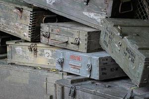 A stack of old wooden military green boxes with ammunition. photo