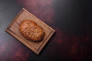 delicioso pan crujiente con cereales en una tabla de cortar de madera foto