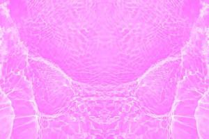 Defocus blurred transparent purple colored clear calm water surface texture with splashes and bubbles. Trendy abstract nature background. Water waves in sunlight with copy space. Pink water drop shine photo