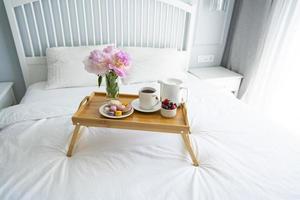 Tray with breakfast on bed. photo