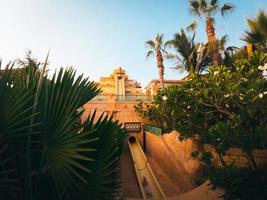 Dubai, United Arab Emirates, 2022 - visitor take most famous slide in Atlantis water park Neptune tower. Popular fun tourist attraction in Dubai, United Arab Emirates photo