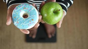 Hand holding donut and apple top view video