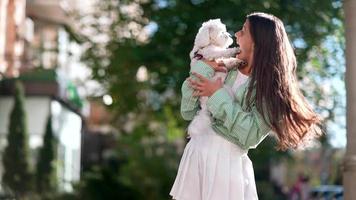 femme tient un petit chien blanc video