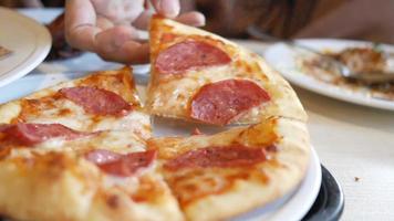 Close up of hand picking slice of pizza from a plate video