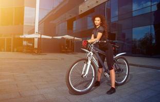 portrait of cute young brunette sports woman with bicycle photo