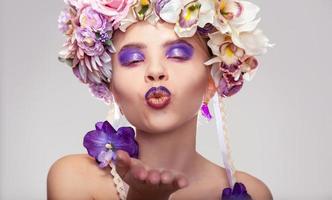 young girl with wreath on head send air kiss photo