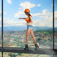 woman builder walks on a crossbar photo
