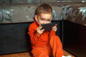 young boy playing mobile games photo
