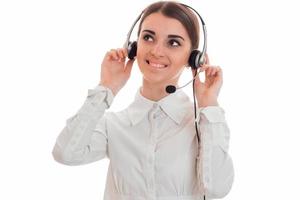 Alegre joven chica de la oficina del centro de llamadas con auriculares y micrófono sonriendo aislado sobre fondo blanco. foto