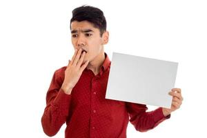 young handsome male model in red shirt with empty placard in hands isolated on white background photo