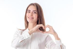smiling girl in shirt shows gesture hands heart isolated on white background photo