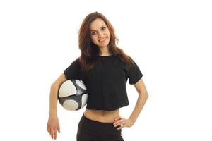 a cheerful young girl in a sports shirt holds the ball and smiling photo