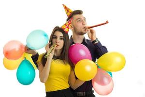 cheerful beautiful wonderful pair celebrate birthday blow horns and carrying a lot of balls photo