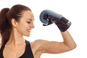woman in boxing gloves shows biceps and smiling photo