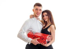 beautiful tall guy with his cute girl holding a big red gift and look into a camera photo